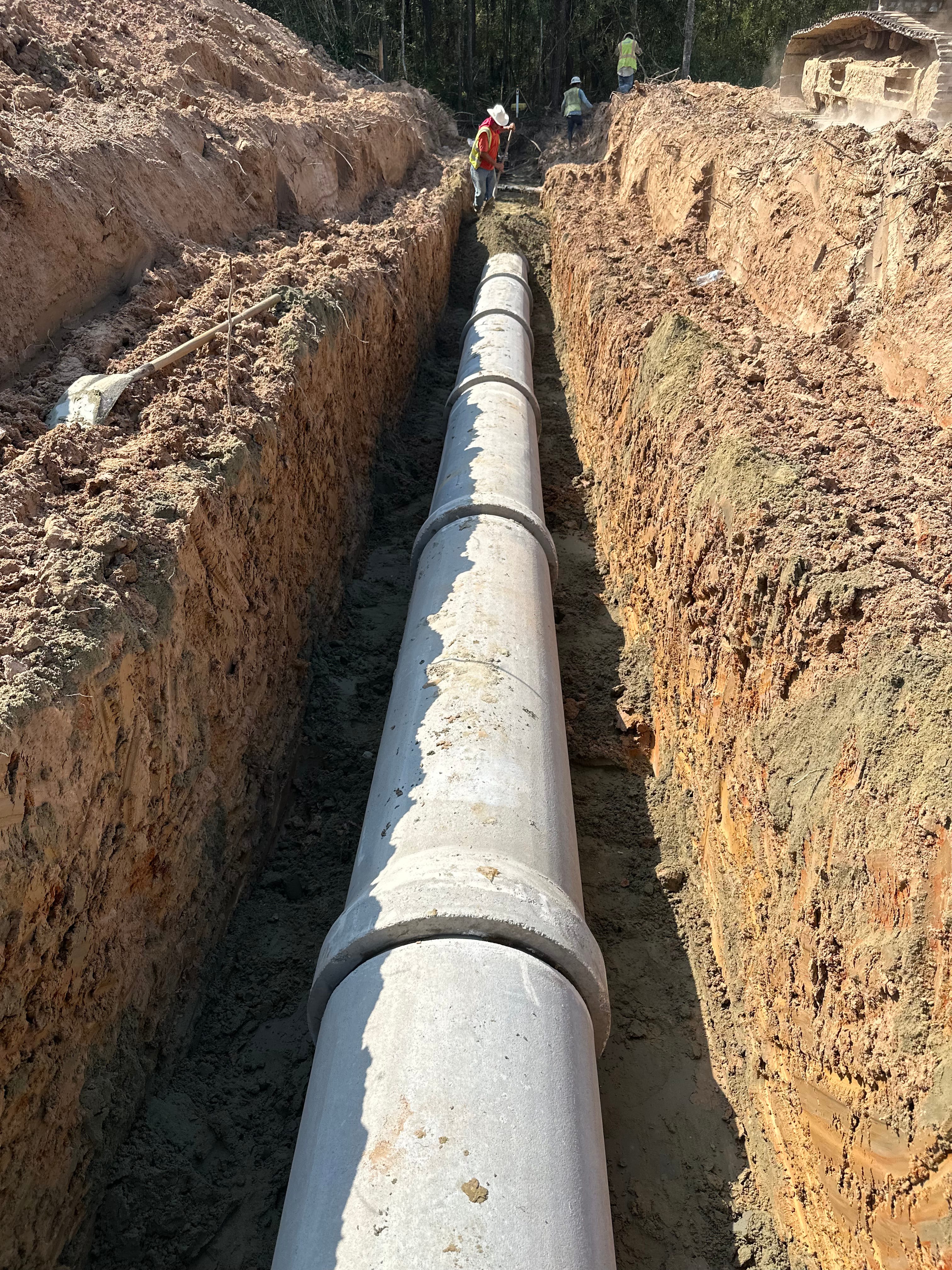 Deep utility trench with large concrete storm or sanitary pipe and embedment